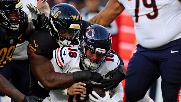 Oct 27, 2024; Landover, Maryland, USA; Washington Commanders defensive tackle Jalyn Holmes (96) sacks Chicago Bears quarterback Caleb Williams (18) during the first half at Commanders Field. Mandatory Credit: Peter Casey-Imagn Images