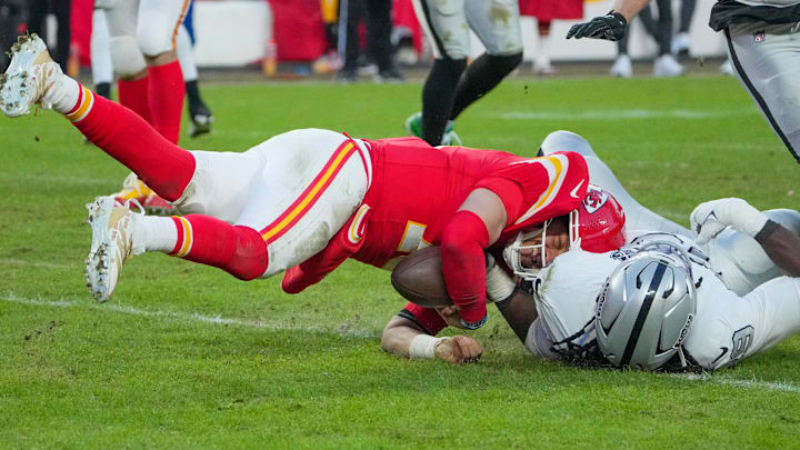 Nov 29, 2024; Kansas City, Missouri, USA; Kansas City Chiefs quarterback Patrick Mahomes (15) is sacked by Las Vegas Raiders defensive tackle Adam Butler (69) during the second half at GEHA Field at Arrowhead Stadium. Mandatory Credit: Denny Medley-Imagn Images