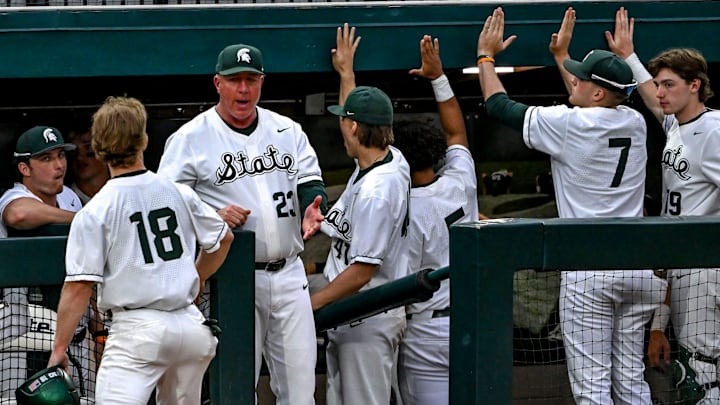 Michigan State's Noah Bright, left, celebrates his score with head coach Jake Boss Jr., center, and the dugout during the eighth inning in the game against Ohio State on Friday, April 18, 2025, at McLane Stadium in East Lansing.