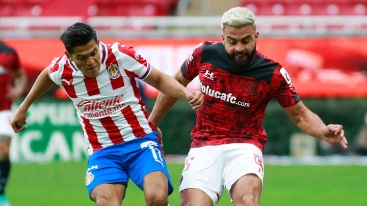 Jesús Sánchez (Chivas) compite por el esférico con el argentino Alexis Canelo (Toluca).