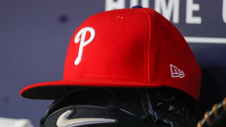 May 26, 2023; Atlanta, Georgia, USA; A detailed view of a Philadelphia Phillies hat and glove on the bench against the Atlanta Braves in the seventh inning at Truist Park. 