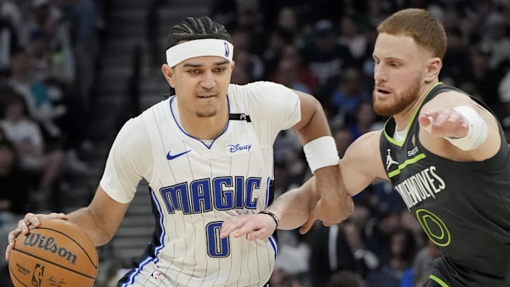 Mar 14, 2025; Minneapolis, Minnesota, USA; Orlando Magic guard Anthony Black (0) works around Minnesota Timberwolves guard Donte DiVincenzo (0) in the third quarter at Target Center. Mandatory Credit: Bruce Kluckhohn-Imagn Images