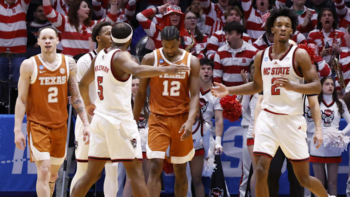Mar 17, 2026; Dayton, OH, USA; NC State Wolfpack guard Tre Holloman (5) celebrates a play with NC State Wolfpack guard Jr. Paul McNeil (2) in the second half against the Texas Longhorns during a first four game of the men's 2026 NCAA Tournament at University of Dayton Arena. Mandatory Credit: Rick Osentoski-Imagn Images