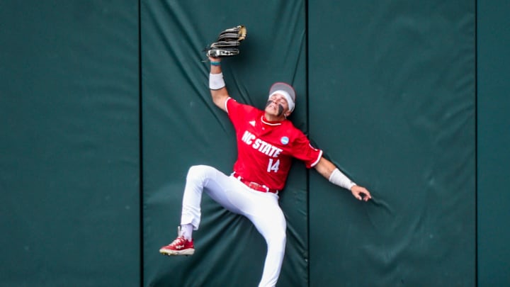 NC State Wolfpack's Ty Head (14) makes a catch at the wall against the Stetson Hatters during the NCAA Baseball Regional Tournament at Plainsman Park in Auburn, Ala., on Friday May 30, 2025.