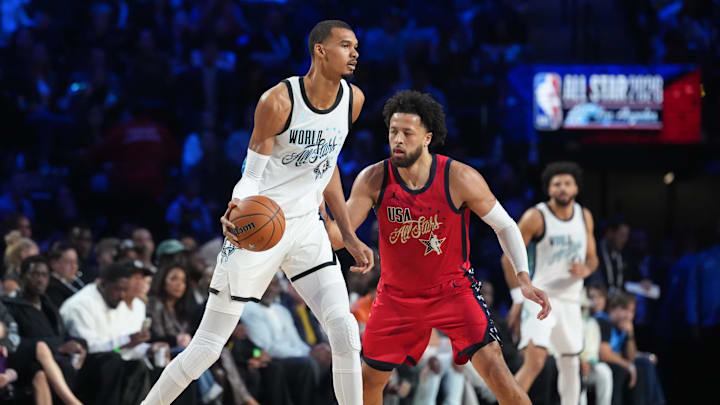 Feb 15, 2026; Inglewood, California, USA; Team World center Victor Wembanyama (1) of the San Antonio Spurs controls the ball while defend by Team USA Stars guard Cade Cunningham (2) of the Detroit Pistons in game one during the 75th NBA All Star Game at Intuit Dome. Mandatory Credit: Kirby Lee-Imagn Images