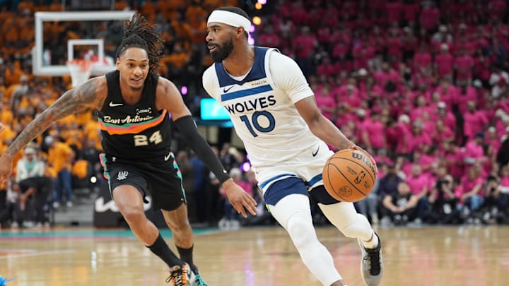 May 4, 2026; San Antonio, Texas, USA; Minnesota Timberwolves guard Mike Conley (10) dribbles against San Antonio Spurs guard Devin Vassell (24) in the first half during game one of the second round of the 2026 NBA Playoffs at Frost Bank Center.