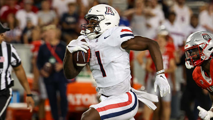 Arizona Wildcats running back Jacory Croskey-Merritt runs the ball for a score while New Mexico Lobos safety Christian Ellis.