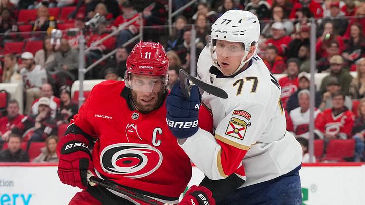 Jan 16, 2026; Raleigh, North Carolina, USA;  Carolina Hurricanes center Jordan Staal (11) and Florida Panthers defenseman Niko Mikkola (77) battle during the first period at Lenovo Center. Mandatory Credit: James Guillory-Imagn Images