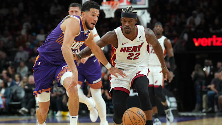 Nov 6, 2024; Phoenix, Arizona, USA; Phoenix Suns guard Devin Booker (1) and Miami Heat forward Jimmy Butler (22) chase a loose ball during the second half at Footprint Center. Mandatory Credit: Joe Camporeale-Imagn Images