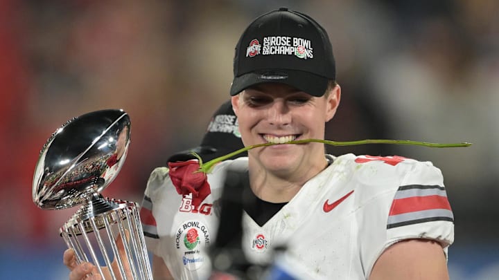 Jan 1, 2025; Pasadena, CA, USA;  Ohio State Buckeyes quarterback Will Howard (18) celebrates with the Leishman Trophy after defeating the Oregon Ducks in the 2025 Rose Bowl college football quarterfinal game at Rose Bowl Stadium. Mandatory Credit: Jayne Kamin-Oncea-Imagn Images