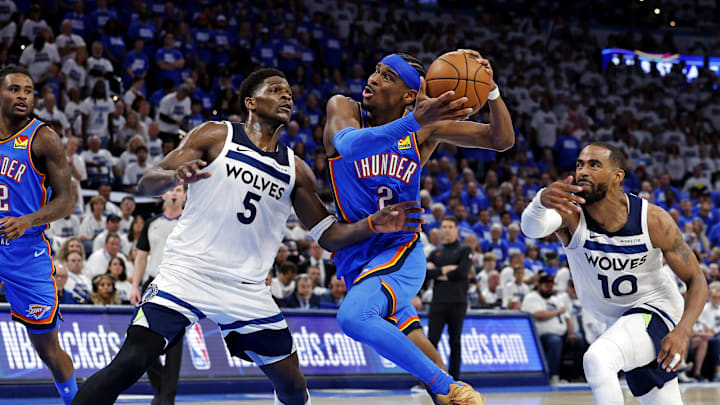 May 28, 2025; Oklahoma City, Oklahoma, USA; Oklahoma City Thunder guard Shai Gilgeous-Alexander (2) drives to the basket against Minnesota Timberwolves guard Anthony Edwards (5) and guard Mike Conley (10) during the fourth quarter in game five of the western conference finals for the 2025 NBA Playoffs at Paycom Center. Mandatory Credit: Alonzo Adams-Imagn Images
