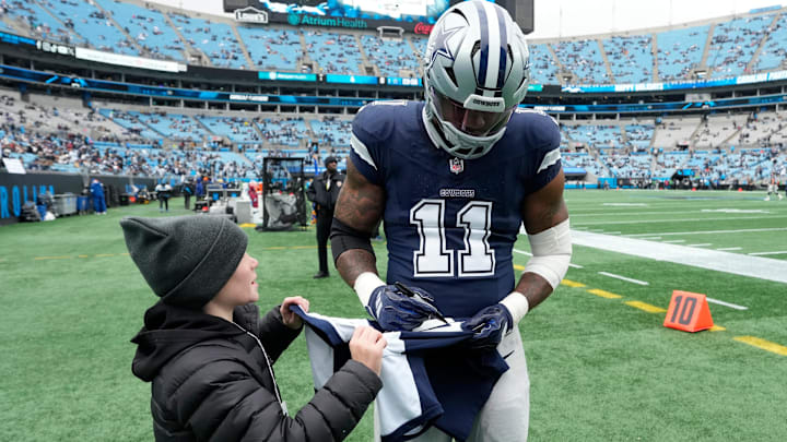 Dec 15, 2024; Charlotte, North Carolina, USA;  Dallas Cowboys linebacker Micah Parsons (11) signs a jersey for a fan before the game at Bank of America Stadium. Mandatory Credit: Bob Donnan-Imagn Images