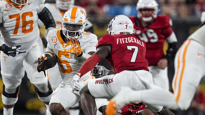Sep 7, 2024; Charlotte, North Carolina, USA; Tennessee Volunteers running back Dylan Sampson (6) runs as North Carolina State Wolfpack safety Bishop Fitzgerald (7) defends during the second half at the Dukes Mayo Classic at Bank of America Stadium. Mandatory Credit: Jim Dedmon-Imagn Images