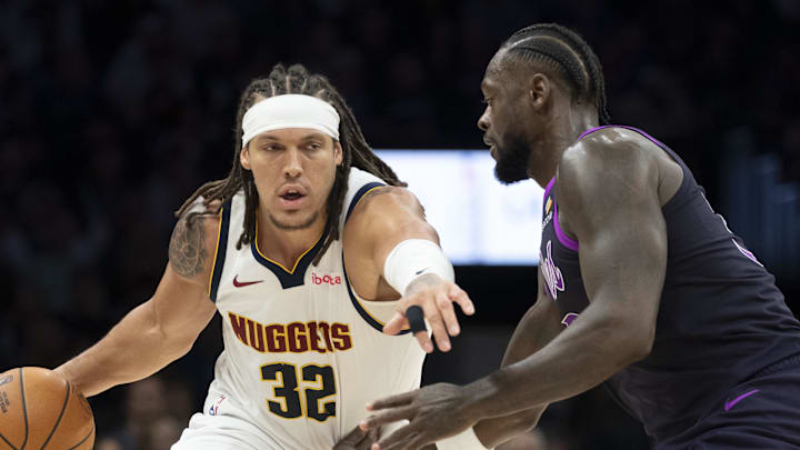 Nov 15, 2025; Minneapolis, Minnesota, USA; Denver Nuggets forward Aaron Gordon (32) dribbles the ball past Minnesota Timberwolves forward Julius Randle (30) in the second half at Target Center.