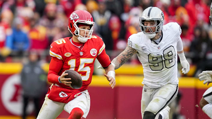 Dec 25, 2023; Kansas City, Missouri, USA; Kansas City Chiefs quarterback Patrick Mahomes (15) scrambles against Las Vegas Raiders defensive end Maxx Crosby (98) during the second half at GEHA Field at Arrowhead Stadium. Mandatory Credit: Jay Biggerstaff-Imagn Images
