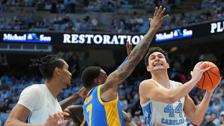Feb 14, 2026; Chapel Hill, North Carolina, USA; North Carolina Tar Heels guard Luka Bogavac (44) with the ball as forward Jarin Stevenson (15) looks on and Pittsburgh Panthers guard Damarco Minor (7) defends in the second half at Dean E. Smith Center. Mandatory Credit: Bob Donnan-Imagn Images