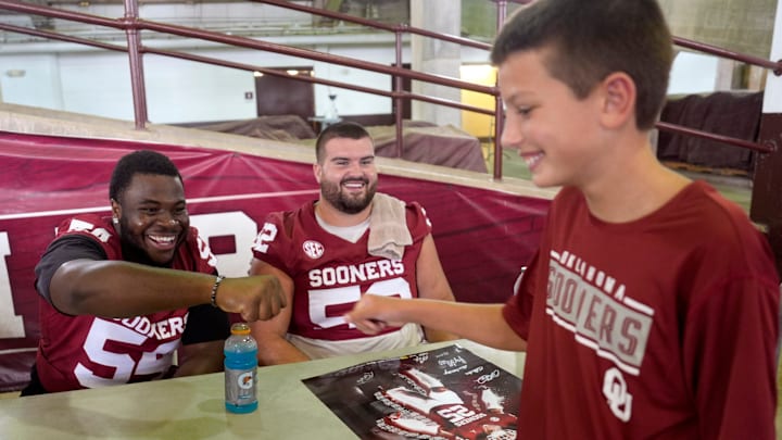 Oklahoma offensive lineman Febechi Nwaiwu (54) daps up a fan at Meet the Sooners Day.