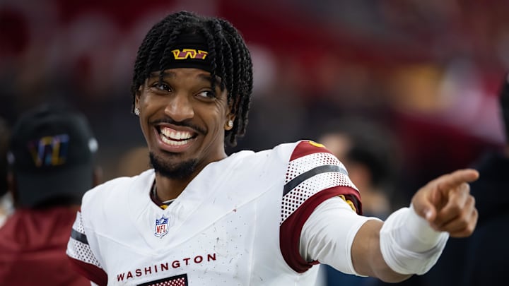 Sep 29, 2024; Glendale, Arizona, USA; Washington Commanders quarterback Jayden Daniels (5) celebrates against the Arizona Cardinals at State Farm Stadium. Mandatory Credit: Mark J. Rebilas-Imagn Images