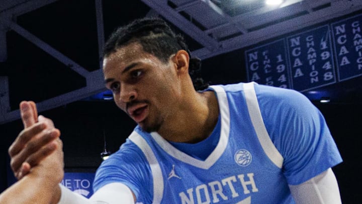 Dec 2, 2025; Lexington, Kentucky, USA; North Carolina Tar Heels guard Derek Dixon (3) is helped to his feet by center Henri Veesaar (13) and forward Jarin Stevenson (15) during the first half against the Kentucky Wildcats at Rupp Arena at Central Bank Center. Mandatory Credit: Jordan Prather-Imagn Images