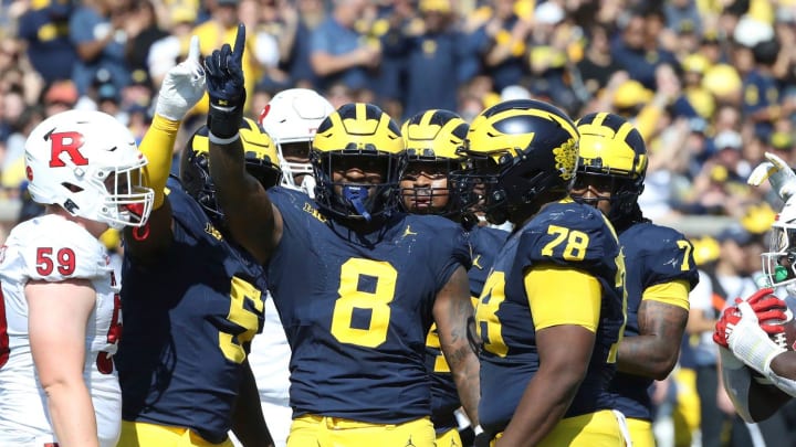 Michigan Wolverines defender Derrick Moore (8) celebrates a stop on Rutgers Scarlet Knights running back Kyle Monangai (5) during the first half at Michigan Stadium, Saturday, Sept. 23, 2023.