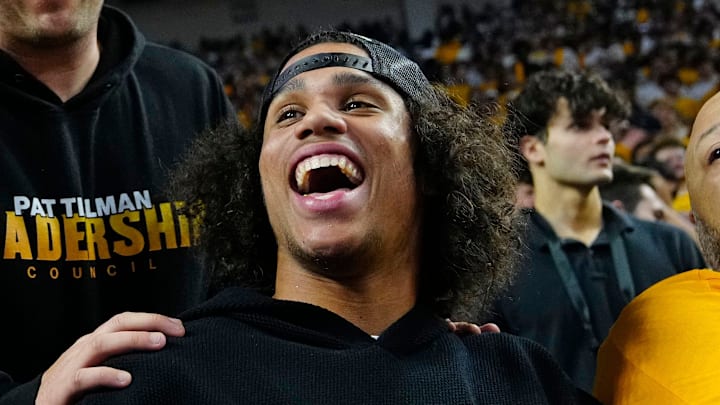 Arizona State football coach Kenny Dillingham (center) talks with former Arizona State guard James Harden (L) and wide receiver Jordyn Tyson during a game at Desert Financial Arena in Tempe, Ariz. on Jan. 31, 2026.