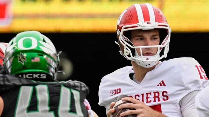 Oct 11, 2025; Eugene, Oregon, USA; Indiana Hoosiers quarterback Fernando Mendoza (15) drops back with the ball and offensive lineman Pat Coogan (78) blocks against Oregon Ducks linebacker Teitum Tuioti (44) during the first quarter at Autzen Stadium. Mandatory Credit: Troy Wayrynen-Imagn Images