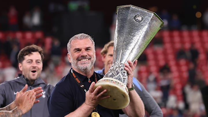 Ange Postecoglou hoists the Europa League trophy after defeating Manchester United in the final.