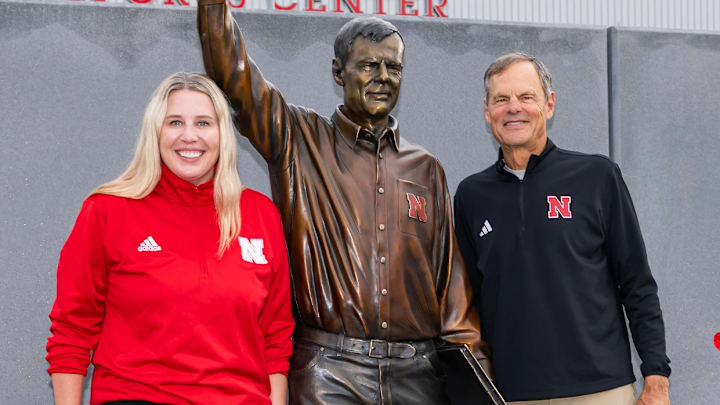 Former Nebraska volleyball coach John Cook poses next to his statue with his successor Dani Busboom Kelly.