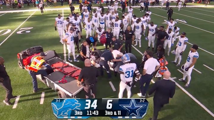 Detroit Lions players surround Aidan Hutchinson.