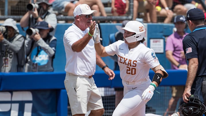  Texas Longhorns utility Katie Stewart slaps the hand of head coach Mike White as she rounds third after her home run in the fourth inning against the Tennessee Lady Volunteers.