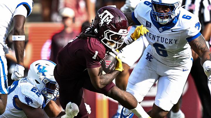 Texas A&M Aggies wide receiver Mario Craver (1) runs the ball as Kentucky Wildcats linebacker Grant Godfrey (22) and defensive tackle Ahmad Breaux (6) make the tackle at Kyle Field. 