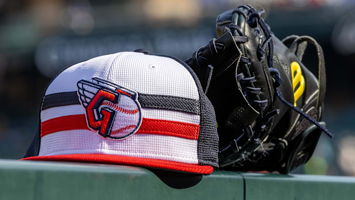 Jul 8, 2024; Detroit, Michigan, USA; A Cleveland Guardians baseball cap and glove sit on the dugout rail before the game against the Detroit Tigers at Comerica Park. Mandatory Credit: David Reginek-Imagn Images