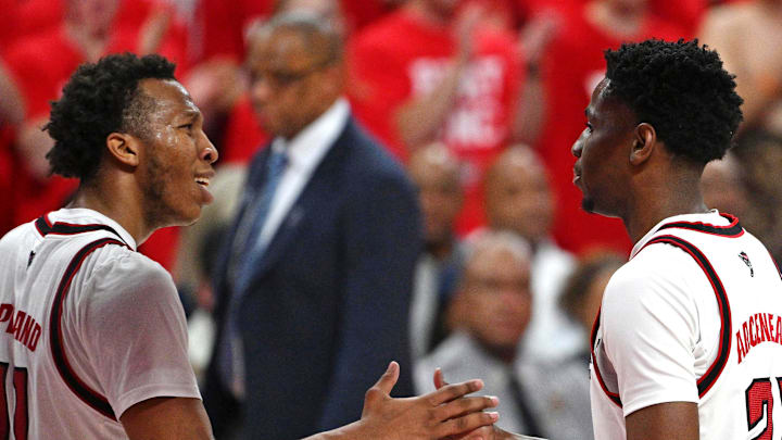 Feb 17, 2026; Raleigh, North Carolina, USA;  NC State Wolfpack guard Quadir Copeland (11) and guard Terrance Arceneaux (21) celebrate in front of the North Carolina Tar Heels bench during the first half at Lenovo Center. Mandatory Credit: Zachary Taft-Imagn Images