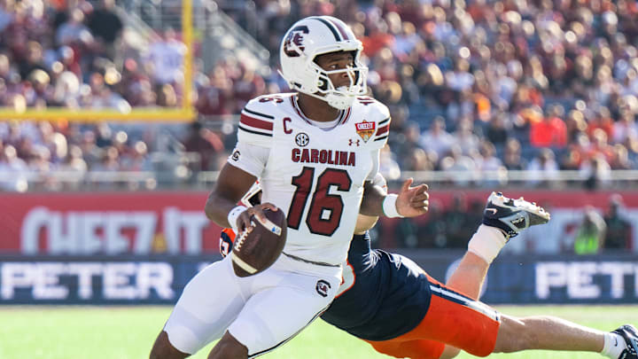 Dec 31, 2024; Orlando, FL, USA; South Carolina Gamecocks quarterback LaNorris Sellers (16) runs the ball against Illinois Fighting Illini linebacker Joe Barna (43) in the first quarter at Camping World Stadium. Mandatory Credit: Jeremy Reper-Imagn Images