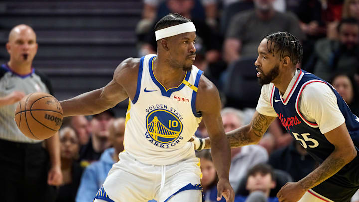 Apr 13, 2025; San Francisco, California, USA; Golden State Warriors forward Jimmy Butler III (10) dribbles the ball against LA Clippers forward Derrick Jones Jr. (55) as referee Jacyn Goble (68) watches the play during the fourth quarter at Chase Center. Mandatory Credit: Robert Edwards-Imagn Images