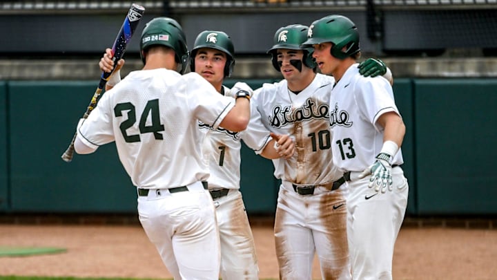 Michigan State's Sam Busch, left, crosses home plate after a home run against Ohio State during the fifth inning on Friday, April 18, 2025, at McLane Stadium in East Lansing. From left, MSU's Ryan McKay, Nick Williams and Parker Picot greet Bush at the plate.