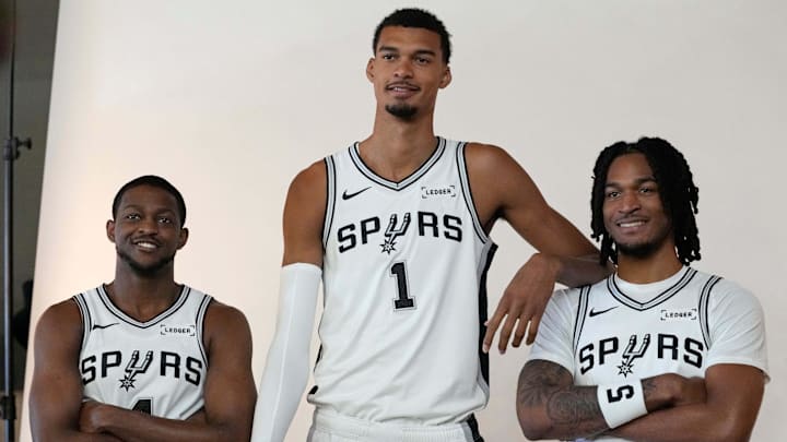Sep 29, 2025; San Antonio, TX, USA; San Antonio Spurs forward-center Victor Wembanyama (1) along with guards De’Aaron Fox (4) and Stephon Castle (5) pose for photos during Media Day at Victory Capital Performance Center in San Antonio. Mandatory Credit: Scott Wachter-Imagn Images Sep 29, 2025; San Antonio, TX, USA; San Antonio Spurs forward-center Victor Wembanyama (1) along with guards De’Aaron Fox (4) and Stephon Castle (5) pose for photos during Media Day at Victory Capital Performance Center in San Antonio. Mandatory Credit: Scott Wachter-Imagn Images