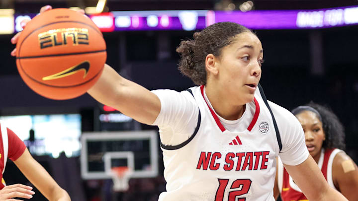 Nov 9, 2025; Charlotte, North Carolina, USA; NC State Wolfpack forward Khamil Pierre (12) controls the ball against the Southern California Trojans during the second quarter of the Ally Tipoff game at Spectrum Center. Mandatory Credit: Cory Knowlton-Imagn Images