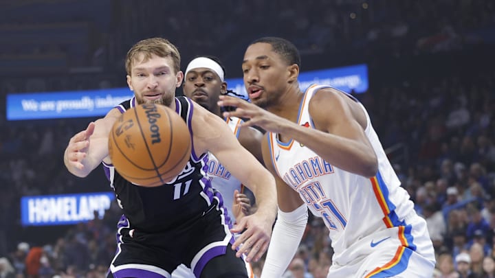 Oct 28, 2025; Oklahoma City, Oklahoma, USA; Sacramento Kings forward Domantas Sabonis (11) and Oklahoma City Thunder guard Aaron Wiggins (21) reach for a loose ball during the first quarter at Paycom Center. Mandatory Credit: Alonzo Adams-Imagn Images