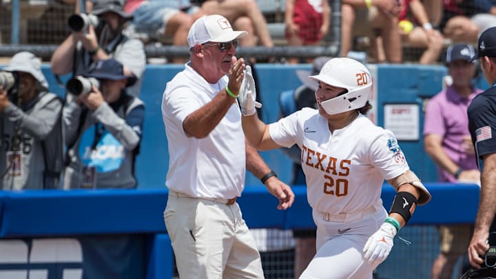 Texas Longhorns utility Katie Stewart slaps the hand of head coach Mike White as she rounds third after her home run in the fourth inning against the Tennessee Lady Volunteers.