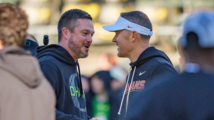 Oregon head coach Dan Lanning, left, and USC head coach Lincoln Riley shake hands before the game as the Oregon Ducks host the USC Trojans on Nov. 22, 2025, at Autzen Stadium in Eugene, Oregon.