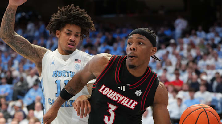 Feb 23, 2026; Chapel Hill, North Carolina, USA; Louisville Cardinals guard Ryan Conwell (3) passes the ball as North Carolina Tar Heels forward Jonathan Powell (11) defends in the first half at Dean E. Smith Center. Mandatory Credit: Bob Donnan-Imagn Images