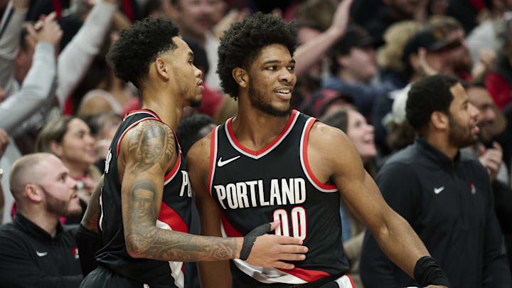Jan 31, 2024; Portland, Oregon, USA; Portland Trail Blazers guard Scoot Henderson (00) celebrates with guard Anfernee Simons (1) during the second half against the Milwaukee Bucks at Moda Center. Mandatory Credit: Troy Wayrynen-Imagn Images