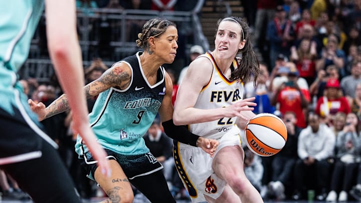 Indiana Fever guard Caitlin Clark (22) dribbles  the ball while New York Liberty guard Natasha Cloud (9) defends in the second half at Gainbridge Fieldhouse.