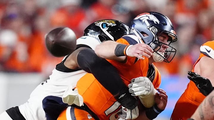 Dec 21, 2025; Denver, Colorado, USA; Jacksonville Jaguars defensive end Travon Walker (44) hits Denver Broncos quarterback Bo Nix (10) during the second half at Empower Field at Mile High. Mandatory Credit: Ron Chenoy-Imagn Images
