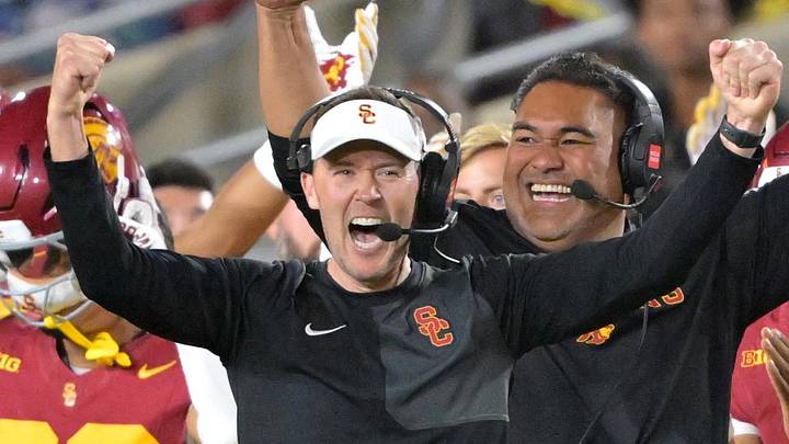 Oct 11, 2025; Los Angeles, California, USA;  USC Trojans head coach Lincoln Riley (wearing white visor) celebrates along with defensive end coach Shaun Nua after kicker Ryon Sayeri (48) hit a 54-yard field goal in the second half against the Michigan Wolverines at United Airlines Field at the Los Angeles Memorial Coliseum. Mandatory Credit: Jayne Kamin-Oncea-Imagn Images