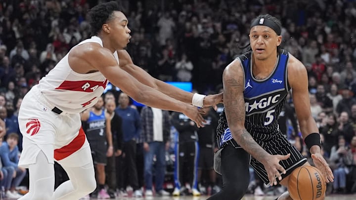 Dec 29, 2025; Toronto, Ontario, CAN; Orlando Magic forward Paolo Banchero (5) dribbles past Toronto Raptors guard Scottie Barnes (4) during the second half at Scotiabank Arena. Mandatory Credit: John E. Sokolowski-Imagn Images