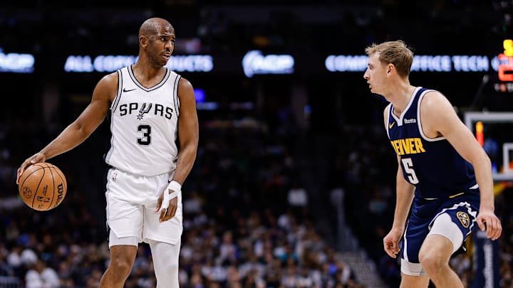 San Antonio Spurs guard Chris Paul controls the ball as Denver Nuggets forward Hunter Tyson.