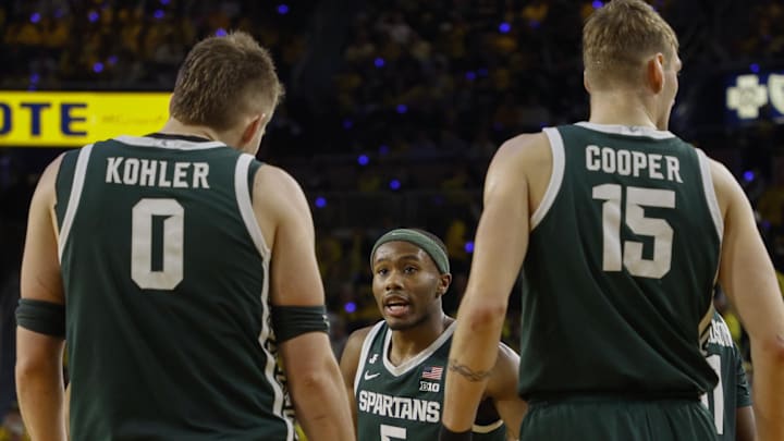 Feb 21, 2025; Ann Arbor, Michigan, USA; Michigan State Spartans guard Tre Holloman (5) talks with forward Jaxon Kohler (0) and center Carson Cooper (15) during the second half at Crisler Center. Mandatory Credit: Brian Bradshaw Sevald-Imagn Images