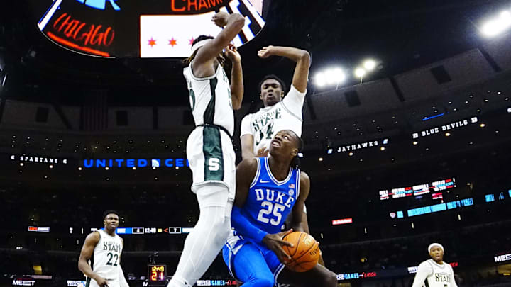 Nov 14, 2023; Chicago, Illinois, USA; Michigan State Spartans forward Coen Carr (55) and forward Xavier Booker (34) defend Duke Blue Devils forward Mark Mitchell (25) during the first half at United Center. Mandatory Credit: David Banks-Imagn Images